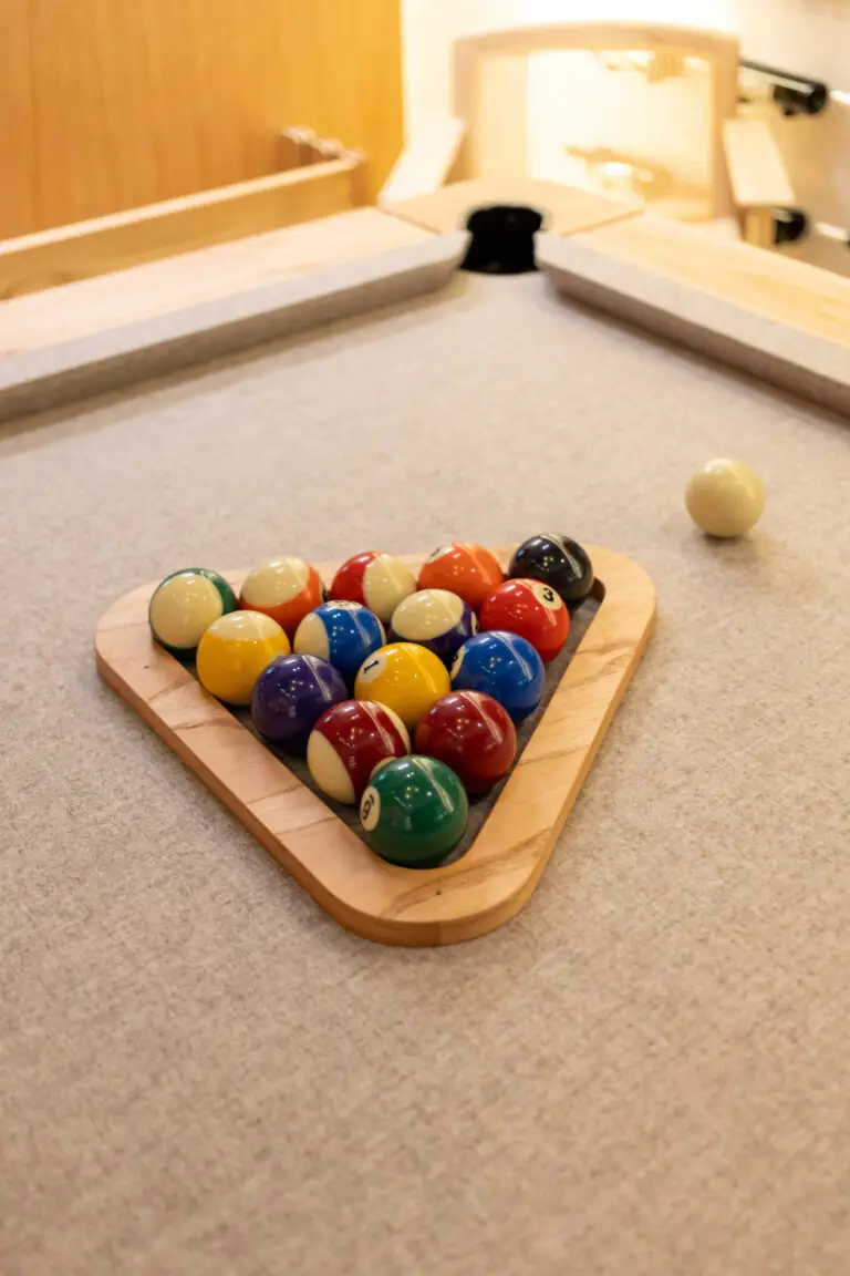 Bolas de sinuca organizadas em um triângulo de madeira sobre a mesa